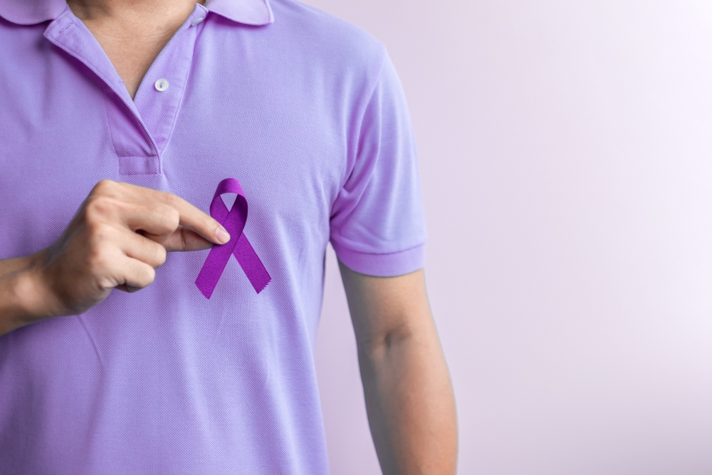 purple ribbon on man's shirt.