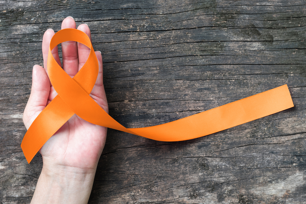 hand holding orange ribbon.